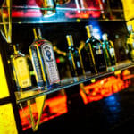 Bottles on glass shelf behind bar
